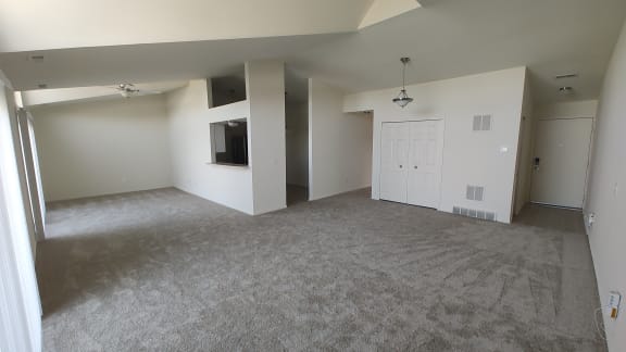 an empty living room with white walls and a tv