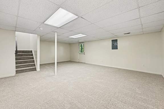 A spacious room with a staircase and a window.