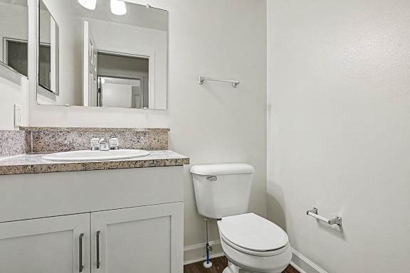 A white toilet sits next to a sink in a bathroom.