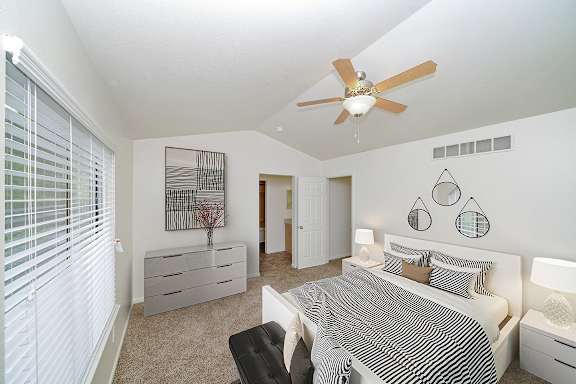 a bedroom with a vaulted ceiling and ceiling fan at Foxwood and The Hermitage, Portage, MI, 49024