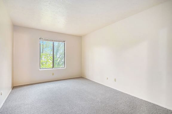 an empty bedroom with a window and carpet at Hickory Village Apartments, Mishawaka, Indiana