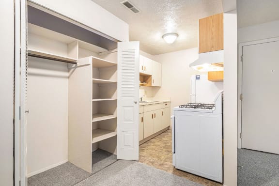 a renovated kitchen with white appliances and a closet at Hickory Village Apartments, Mishawaka, Indiana