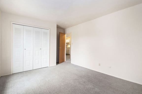 an empty living room with a door to the bathroom at Hickory Village Apartments, Mishawaka