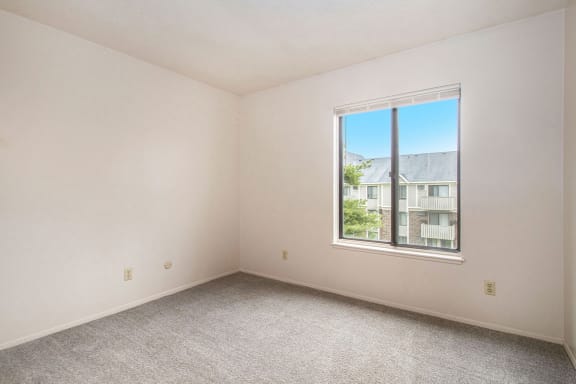 an empty living room with a large window at Hickory Village Apartments, Indiana, 46545