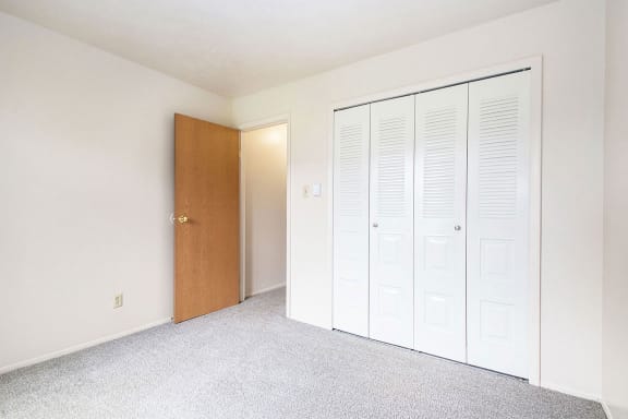 an empty room with a closet and a door at Hickory Village Apartments, Indiana