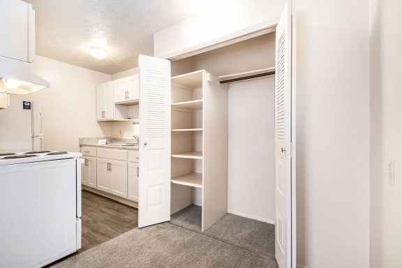 a kitchen with white appliances and a closet at Hickory Village Apartments, Mishawaka