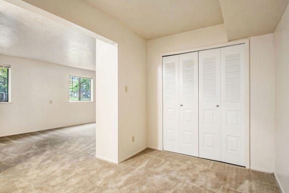 an empty living room with a closet and a door at Hickory Village Apartments, Mishawaka, IN