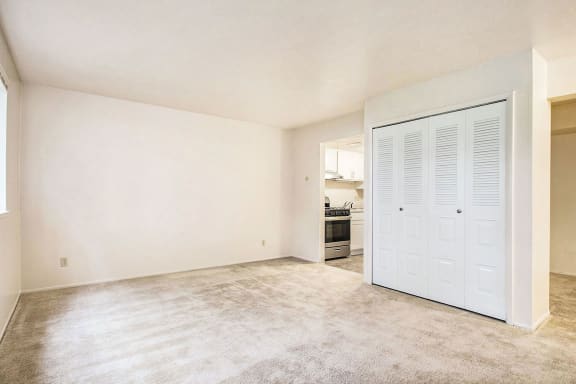 an empty living room with a door to the kitchen at Hickory Village Apartments, Mishawaka, 46545