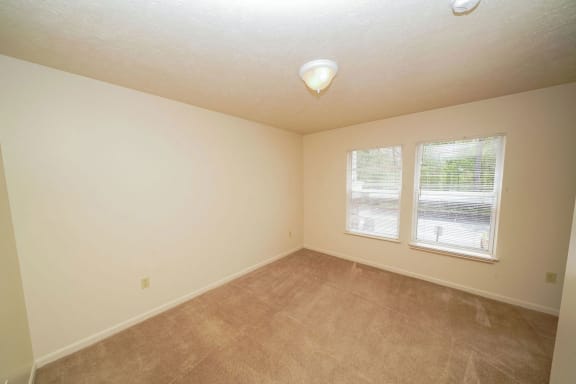 a room with carpet and two windows at The Highlands Apartments, Indiana, 46514