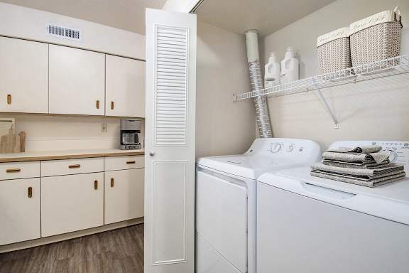 A laundry area with a full size washer and dryer at The Highlands Apartments, Indiana