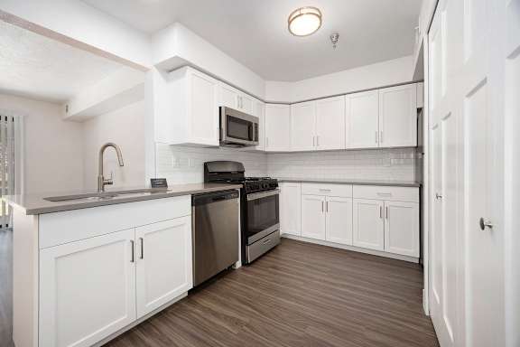 A kitchen with white cabinets and stainless steel appliances