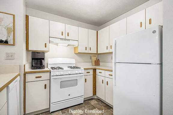 a kitchen with white appliances and white cabinets at The Highlands Apartments, Elkhart