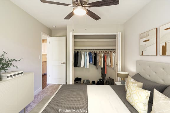 a bedroom with a closet and a ceiling fan  at Hillside Apartments, Wixom