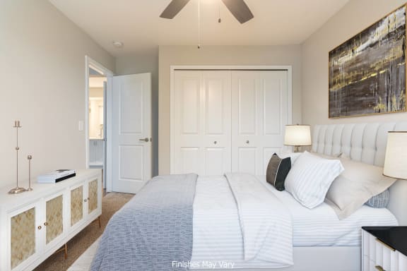 a bedroom with a large bed and a ceiling fan at Hillside Apartments, Wixom, MI