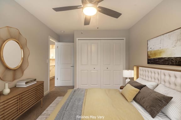 a bedroom with a large bed and a ceiling fan at Hillside Apartments, Wixom