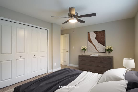 a bedroom with two closets and a ceiling fan at Hillside Apartments, Michigan