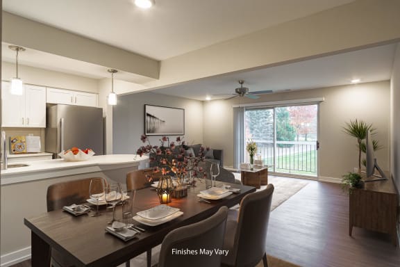 a dining area with a table and chairs and a kitchen in the background at Hillside Apartments, Wixom, Michigan