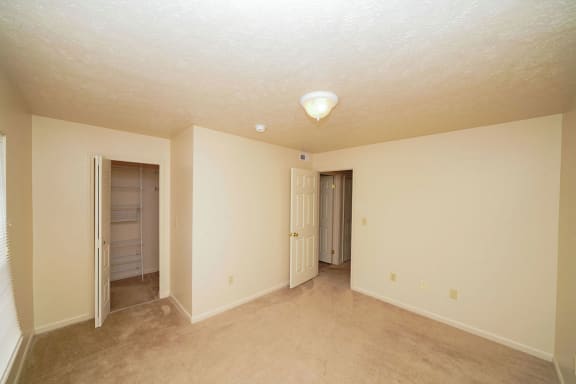 an empty living room with white walls and a door to a closet