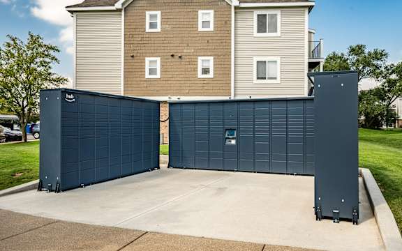 A large blue garage door in front of a two-story building at Huntington Cove Apartments, Merrillville, IN