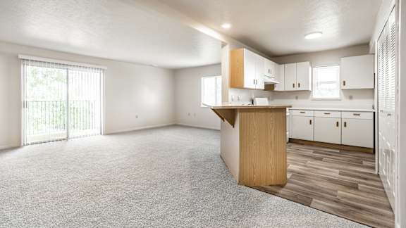 A spacious kitchen with white cabinets and a wooden island at Huntington Cove Apartments, Merrillville, IN