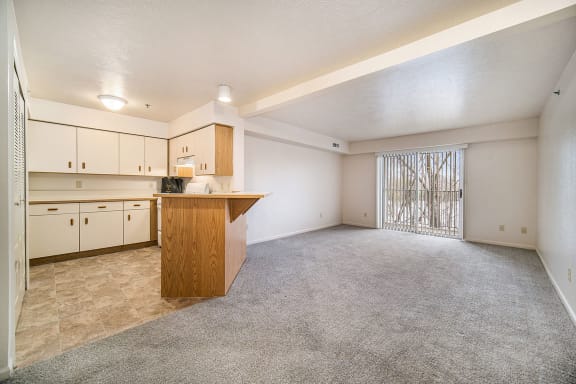 an empty living room and kitchen with a counter  at Hurwich Farms Apartments, South Bend