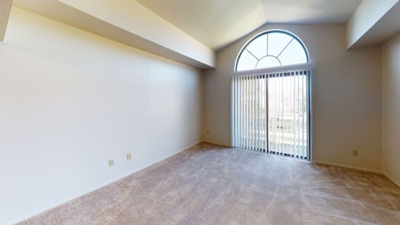 an empty living room with a large window and white walls  at Hurwich Farms Apartments, South Bend, Indiana