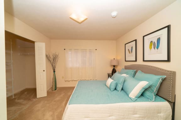 a bedroom with a bed and a closet  at Hurwich Farms Apartments, South Bend, Indiana