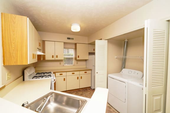 a kitchen with a sink and a washer and dryer  at Hurwich Farms Apartments, South Bend, IN