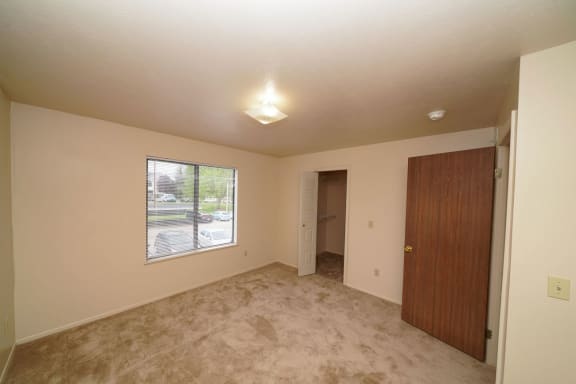 an empty living room with a window and a door  at Hurwich Farms Apartments, South Bend, IN