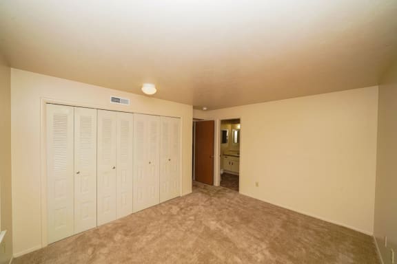 an empty living room with white closets and carpeting  at Hurwich Farms Apartments, South Bend, IN