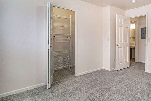 a bedroom with a walk in closet with organizers at Hurwich Farms Apartments in South Bend, IN