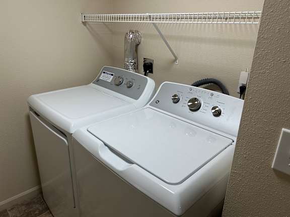 A white washing machine and dryer in a small laundry room.