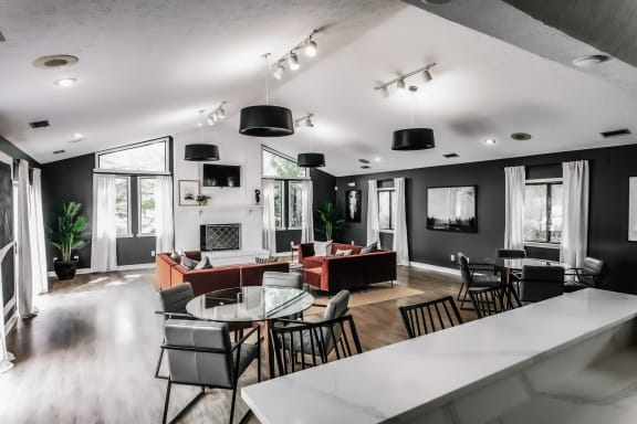 a living room with black walls and a white table and chairs at Bavarian Village Apartments, Indianapolis