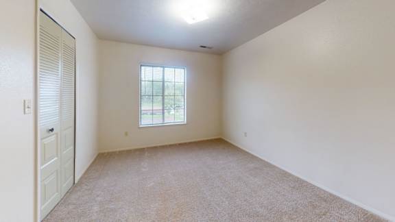 A bedroom with a large window and a walk-in closet at Indian Lakes Apartments, Indiana