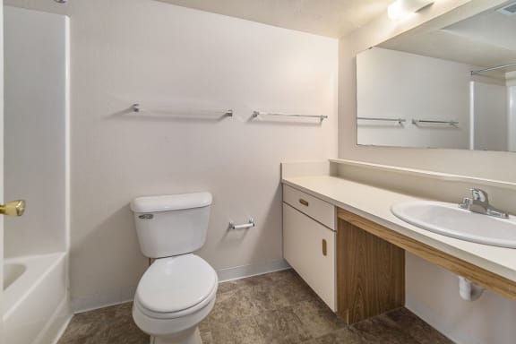 a bathroom with a toilet sink and mirror at Indian Lakes Apartments, Mishawaka