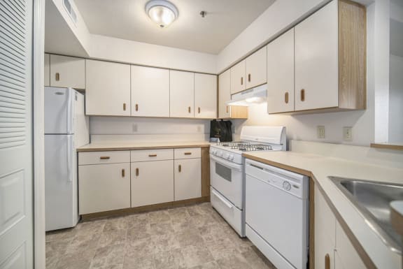 a kitchen with white appliances and white cabinets at Indian Lakes Apartments, Mishawaka, 46545