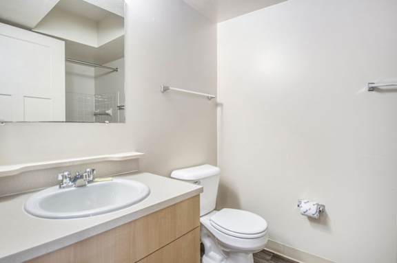 A primary bathroom with a toilet, sink, and a mirror at Indian Lakes Apartments, Mishawaka, IN