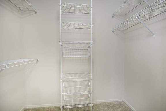a white closet with wire shelving on the wall