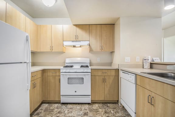 a kitchen with white appliances and wooden cabinets  at Indian Lakes Apartments, Mishawaka, 46545