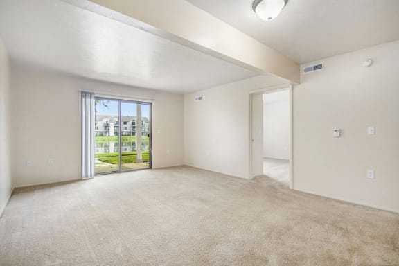 an empty living room with a door to the patio  at Indian Lakes Apartments, Mishawaka, 46545