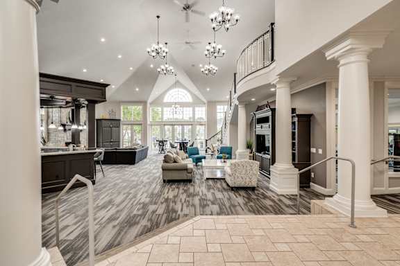 A spacious lobby with a staircase and a chandelier at Westlake Apartments, Michigan