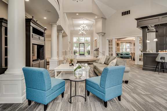 A living room with a blue chair and a white table at Westlake Apartments, Michigan