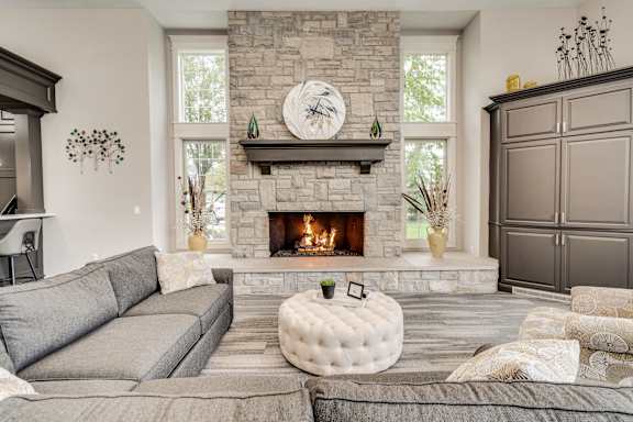A cozy living room with a fireplace and a grey sofa at Westlake Apartments, Michigan