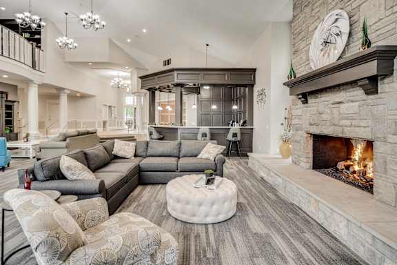A modern living room with a fireplace and a large grey sofa at Westlake Apartments, Michigan