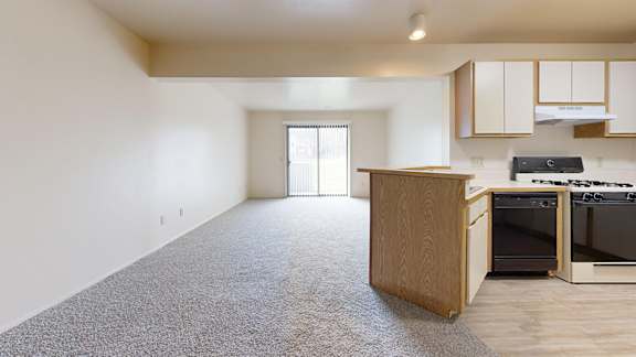 A kitchen with a dishwasher and a dining to living room at Irish Hills Apartments, South Bend, Indiana