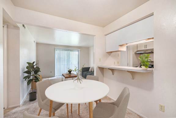 A dining room with a white table, chairs, and a breakfast bar at Irish Hills Apartments, South Bend, Indiana