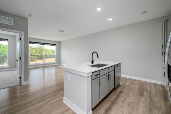 A kitchen with a sink and cabinets in a room with a sliding glass door at Ironwood Flats Apartments, Brandon, FL