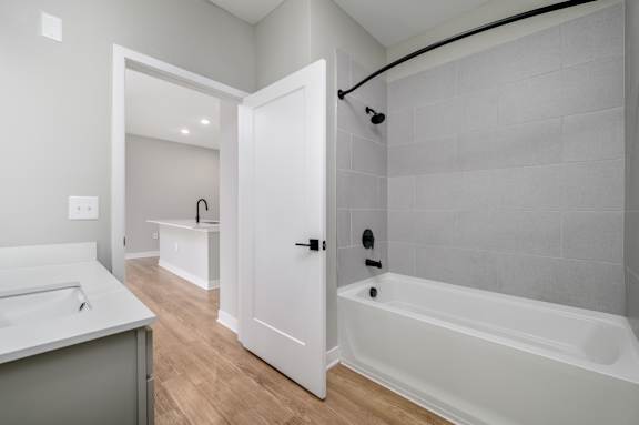 A white bathroom with a tub, sink and shower head at Ironwood Flats Apartments, Brandon, FL, 33511