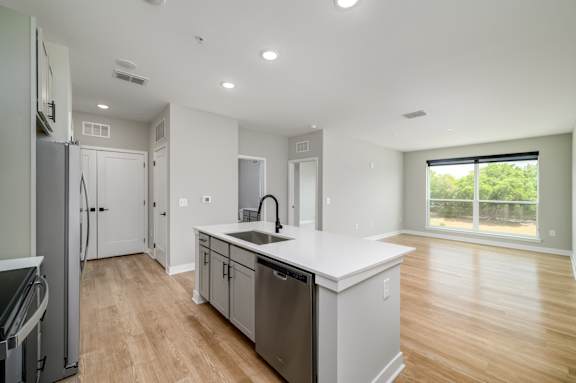 A modern kitchen with stainless steel appliances and wooden flooring at Ironwood Flats Apartments, Brandon, 33511