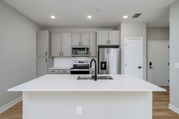 A kitchen with white cabinets and appliances at Ironwood Flats Apartments, Florida